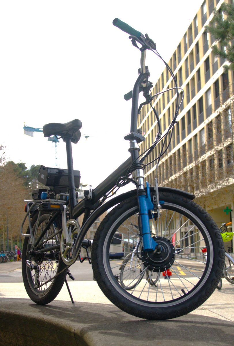 Vélo pliant électrique noir, roues 20 pouces, photographié à Genève