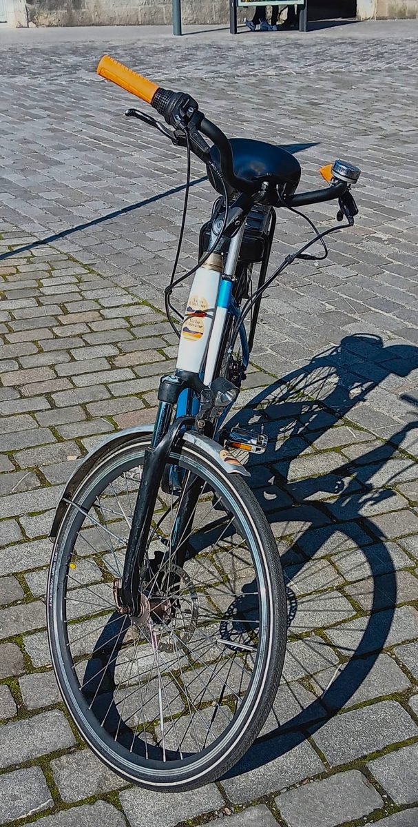 Vélo électrique de ville Kalkhoff vu de face sur des pavés